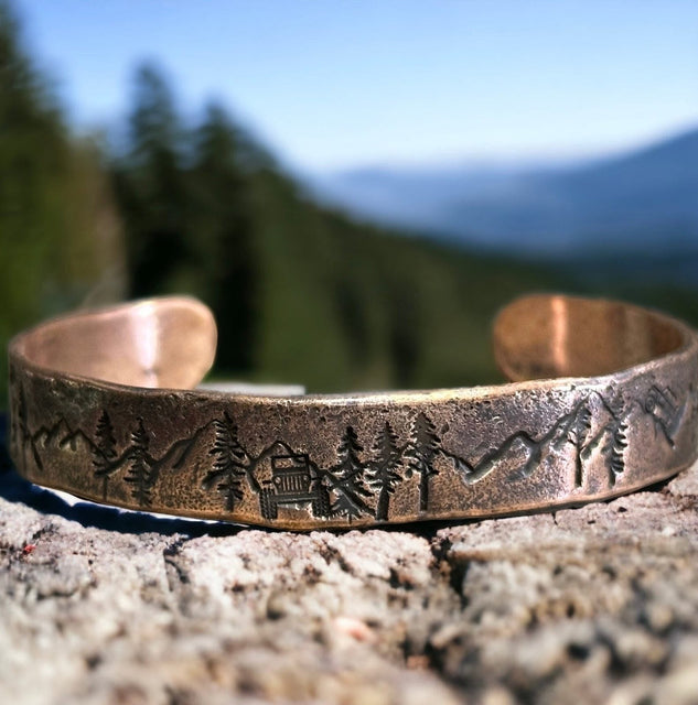 Copper cuff bracelet with a mountain scene and a sport utility vehicle 